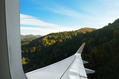 Airplane taking off or landing, view on mountains from window clipart