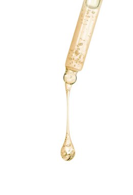 Beyaz arka planda pipetten süzülen kozmetik yağı, yakın plan