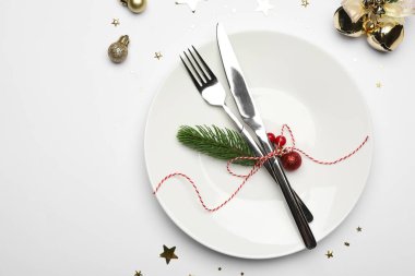 Tabak, çatal bıçak takımı ve beyaz arka planda şenlikli Noel sofrası, düz yatış