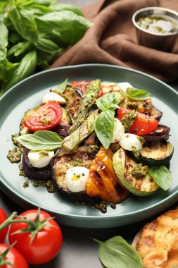 Izgara sebzeli lezzetli salata, pesto sosu ve fesleğen, yakın plan.