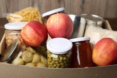 Masadaki kutuda bağış için farklı gıda ürünleri, yakın plan.