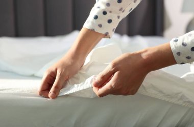 Kadın temiz çarşaf değiştiriyor.