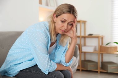Menopoz. Evdeki kanepede baş ağrısı çeken bir kadın, mesaj için yer.