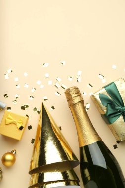 Düz kompozisyon konfeti ve bej arka planda bir şişe köpüklü şarap, mesaj için boşluk. Noel dekoru