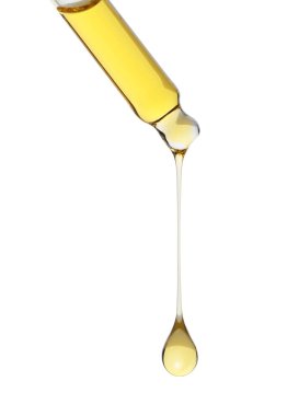 Beyaz arka planda pipetten süzülen kozmetik yağı, yakın plan