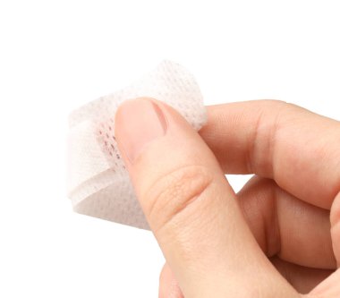 Kadın, beyaz arka plana tıbbi yapıştırıcı bandaj yapıştırıyor. Yakın plan.