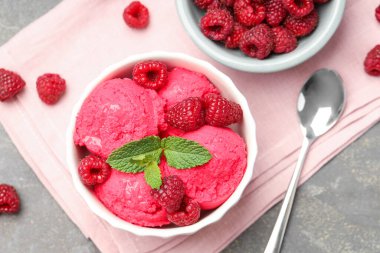 Lezzetli ahududu şerbeti, kasede taze böğürtlen ve gri desenli masada kaşık, düz uzanmış.