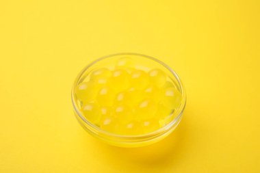 Sarı arka planda parlak tapyoka incileri, yakın plan