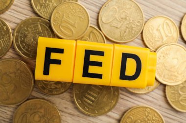 Fed (Federal Rezerv Sistemi) harfli küpler ve tahta masa üzerinde madeni paralar, düz yatıyordu