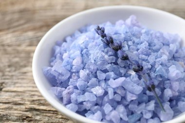 Kasede doğal deniz tuzu ve ahşap masada lavanta, yakın plan.