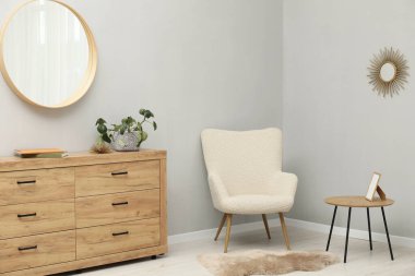 Açık gri duvardaki yuvarlak ayna. İç tasarım