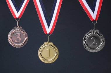 Koyu gri arka planda altın, gümüş ve bronz madalyalar