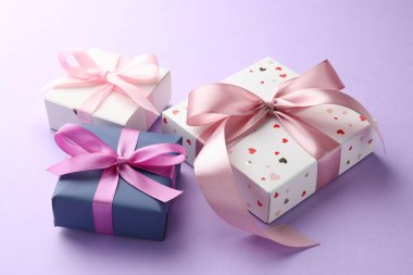 Mor arka planda pembe fiyonklu güzel hediye kutuları