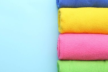 Açık mavi arka planda farklı mikrofiber kumaşlar sarılmış. Metin için boşluk