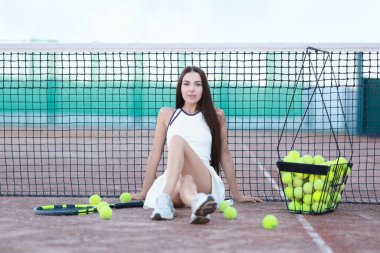 Spor giyimli güzel bir kadın tenis kortunda