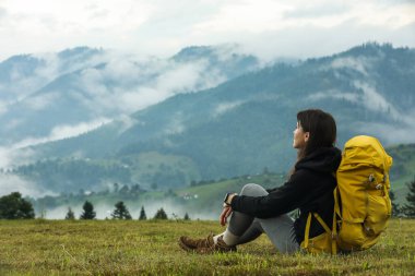 Dağlarda sırt çantalı genç bir yürüyüşçü. Metin için boşluk