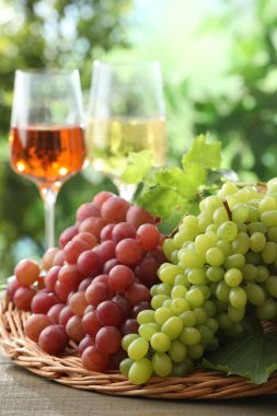 Taze üzümler ve tahta masada bir kadeh şarap.