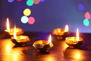 Diwali kutlaması. Karanlık masada bulanık ışıklara karşı Diya lambaları
