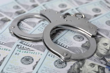 Yozlaşma konsepti. Dolar üzerinden kelepçe, yakın plan.