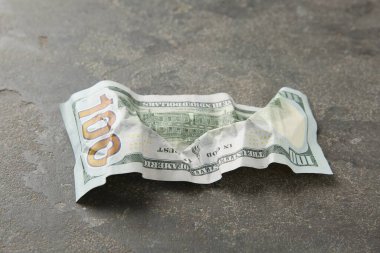 Gri masaya buruşmuş bir dolar banknot, yakın plan.