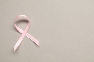 Gri arka planda pembe farkındalık kurdelesi, üst manzara. Metin için boşluk