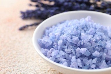 Kasede doğal deniz tuzu ve bej desenli masada lavanta, yakın plan.