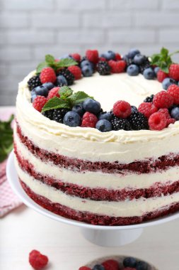 Farklı böğürtlenli ve beyaz masada nane şekerli lezzetli bir sünger kek.