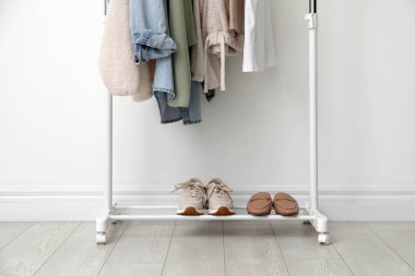 Beyaz duvarın yanında giysi ve ayakkabılarla dizilin.