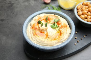 Koyu gri masada servis edilen kırmızı biberli lezzetli humus.