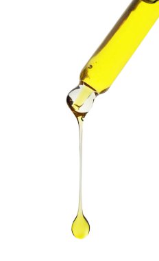 Beyaz arka planda pipetten süzülen kozmetik yağı, yakın plan