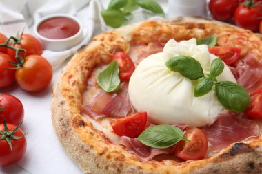 Burrata peynirli, fesleğenli, domatesli ve jambonlu lezzetli pizza.