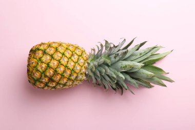 Pembe arka planda taze, olgun bir ananas.