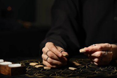 Kehanet minderinde tahta rünleri olan kadın, yakın plan.