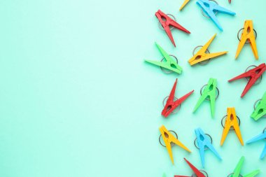 Turkuaz arka planda bir sürü renkli mandal var. Metin için boşluk