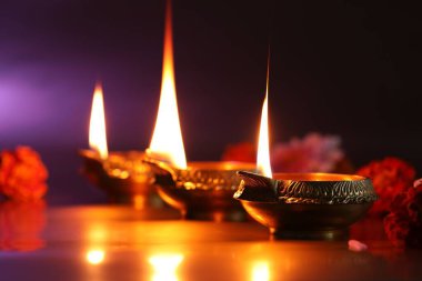 Diwali kutlaması. Diya lambaları ve arkaplanda güzel çiçekler, yakın plan