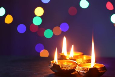 Diwali kutlaması. Karanlık masada bulanık ışıklara karşı Diya lambaları