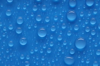 Su damlaları mavi arkaplanda, üst görünümde