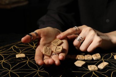 Kehanet minderinde tahta rünleri olan kadın, yakın plan.