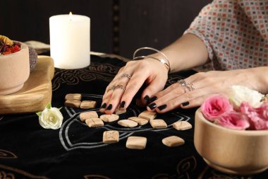 Kehanet minderinde tahta rünleri olan kadın, yakın plan.