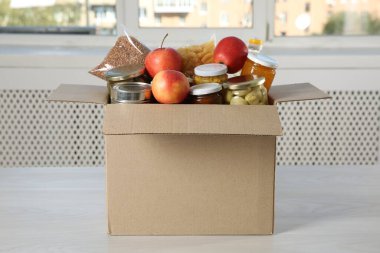 İçerideki ahşap masada bağış yapmak için farklı gıda ürünleri.