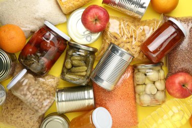 Yiyecek bağışı. Sarı arka planda farklı ürünler, üst görünüm