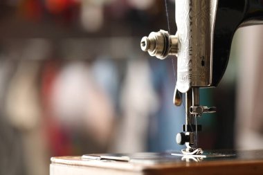 Bulanık arka planda ipliği olan klasik dikiş makinesi, yakın plan. Metin için boşluk