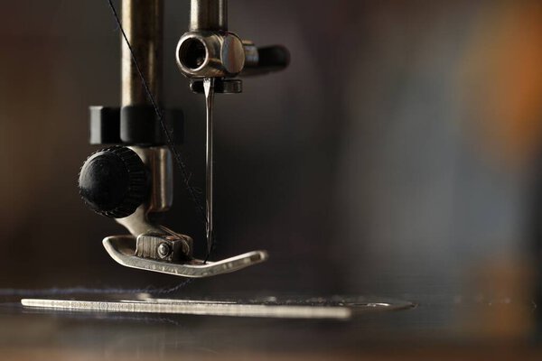 Швейная машина с резьбой на размытом фоне, макропредставление. Пространство для текста
