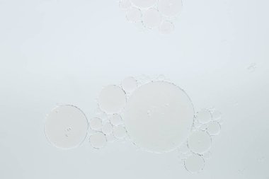 Beyaz arka planda temel yağ kabarcıkları, makro görünüm. Kozmetik ürünü