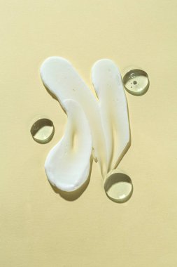 Bej arka planda farklı kozmetik ürünlerinin kokusu, üst görünüm