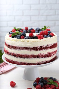 Farklı böğürtlenli ve beyaz masada nane şekerli lezzetli bir sünger kek.