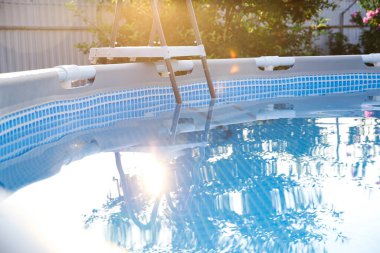 Güneşli bir günde, bahçedeki yüzme havuzunun üstünde, yakın çekim.