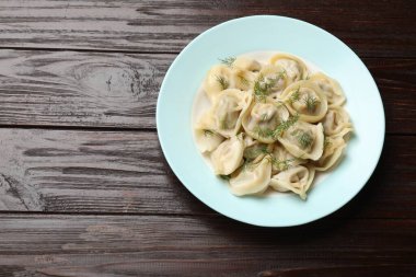 Ahşap masadaki dereotlu leziz pelmeni, üst manzara. Metin için boşluk