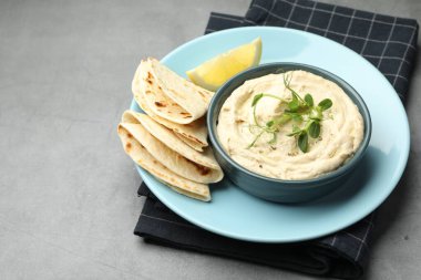 Kasede leziz humus, gri masada pide ve limon, mesaj için yer.