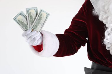 Beyaz arka planda dolar banknotları tutan Noel Baba, yakın plan.